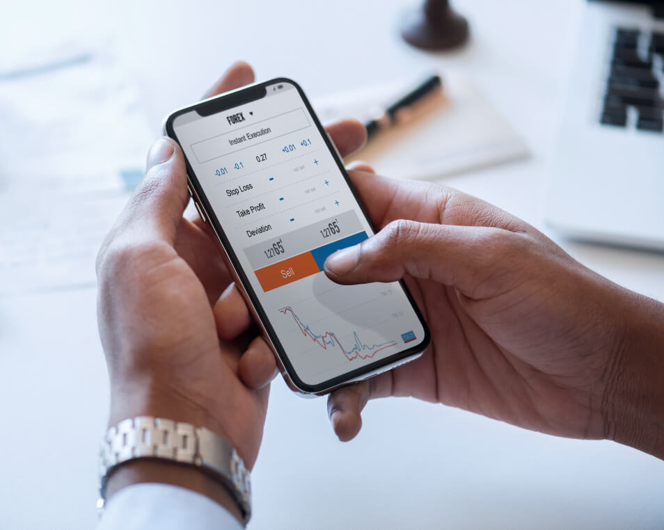 Person holding a smart phone with a stock market application open.